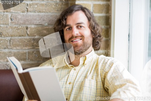 Image of Man With Book In Coffeeshop
