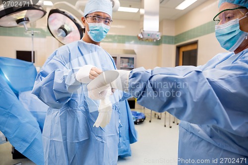 Image of Nurse Assisting Doctor with Sterile Glove