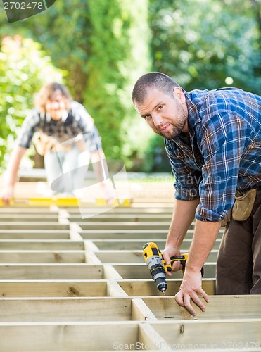 Image of Carpenter Holding Drill At Construction Site