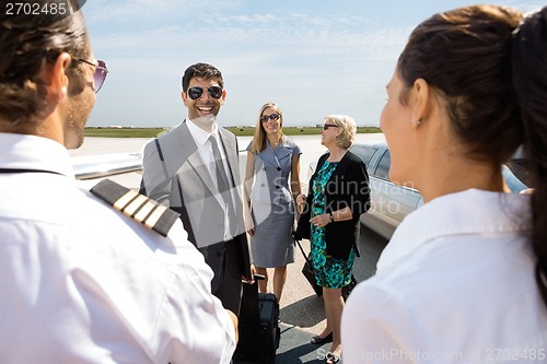 Image of Business People Greeting Pilot And Airhostess At Airport Termina