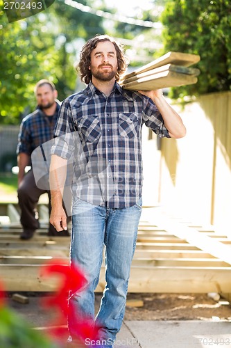 Image of Carpenters Carrying Wooden Planks