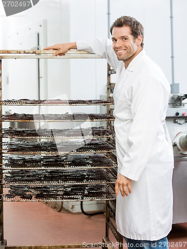 Image of Worker Standing By Rack Of Beef Jerky At Shop