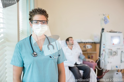 Image of Nurse In Protective Clothing While Patient Receiving Dialysis