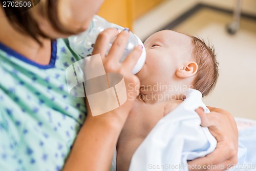 Image of Mother Feeding Milk To Newborn Baby Girl In Hospital