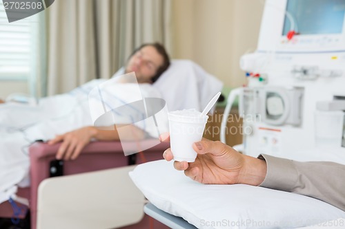 Image of Cancer Patient Holding Glass Of Crushed Ice