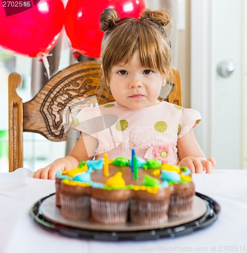 Image of Girl Sitting In Front Of Birthday Cake