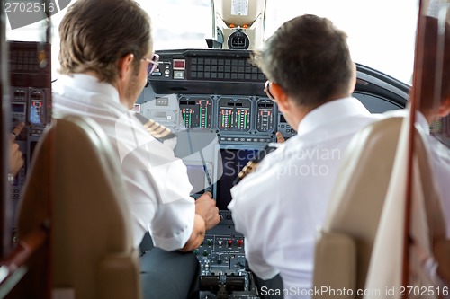 Image of Pilots Operating Controls Of Corporate Jet