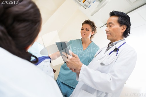 Image of Medical Team With Female Patient In Examination Room