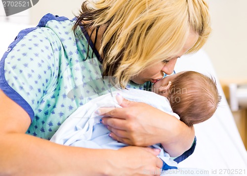 Image of Mother Kissing Newborn Babygirl In Hospital