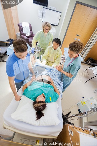 Image of Doctors With Nurse Operating Pregnant Woman During Delivery