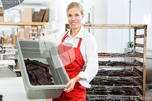 Image of Worker Showing Beef Jerky In Basket At Shop