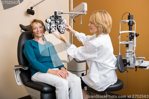 Image of Eye Specialist Adjusting Phoropter For Woman