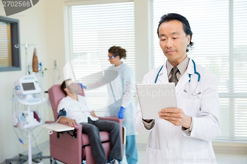 Image of Doctor Using Digital Tablet In Chemo Room