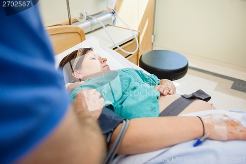 Image of Man's Hand Consoling Pregnant Wife Lying On Hospital Bed