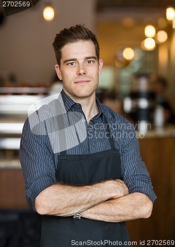 Image of Young Owner Standing Arms Crossed In Cafe