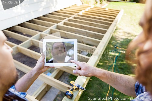 Image of Carpenters Using Digital Tablet At Construction Site