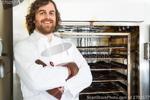 Image of Butcher Standing Arms Crossed By Oven