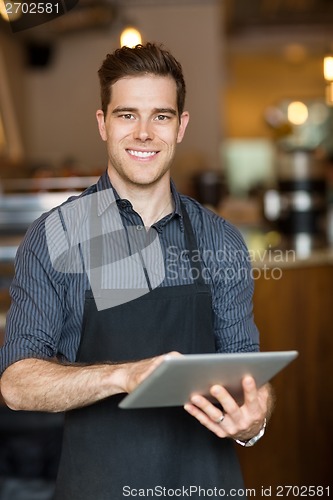 Image of Happy Owner Holding Digital Tablet In Cafe