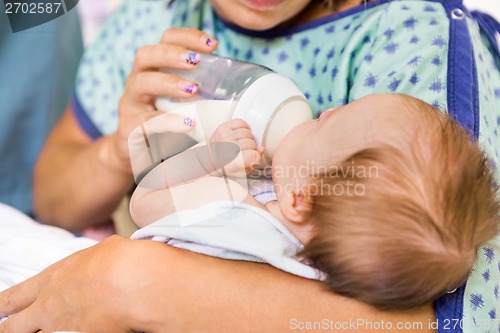 Image of Mother Feeding Milk From Bottle To Newborn Baby