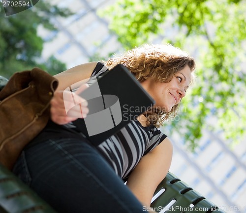 Image of University Student Holding Digital Tablet On Bench