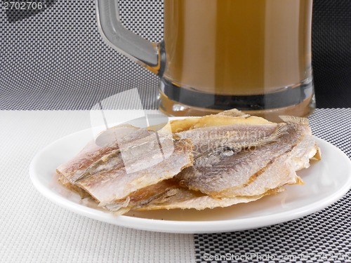 Image of smoked fish and cup of beer on a background