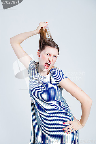 Image of Attractive woman pulling her hair