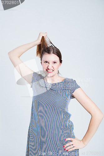 Image of Attractive woman pulling her hair