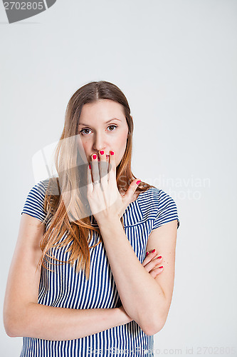 Image of Attractive woman covering mouth with hand