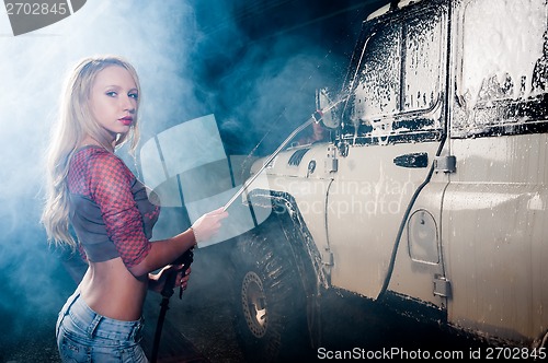Image of young woman washing the car