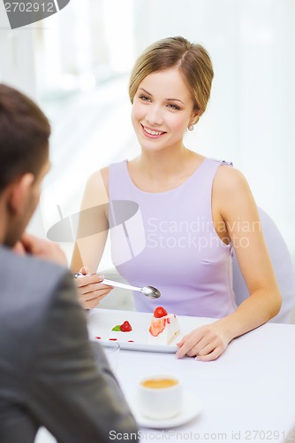 Image of smiling couple eating dessert at restaurant