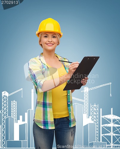 Image of smiling woman in helmet with clipboard