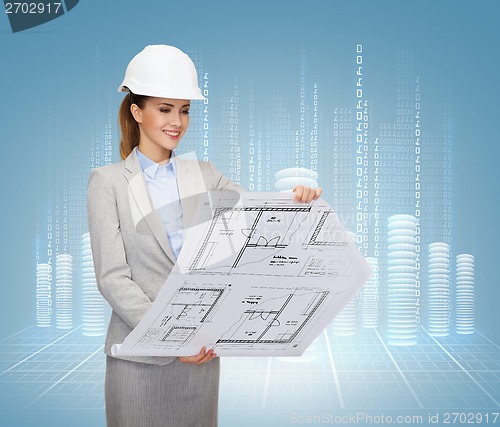 Image of smiling architect in white helmet with blueprints