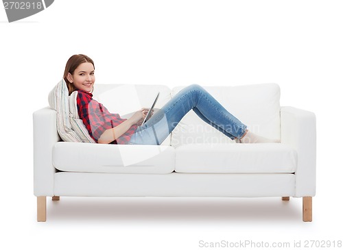 Image of teenage girl sitting on sofa with tablet pc