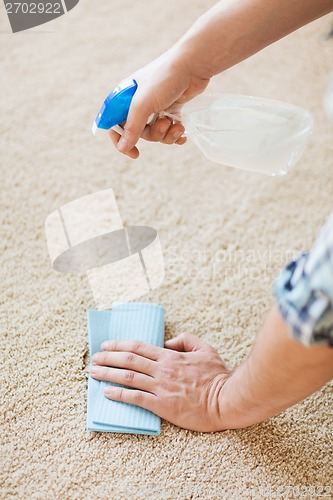 Image of close up of male cleaning stain on carpet