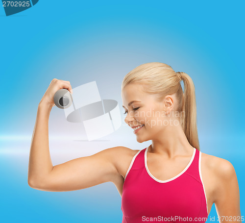 Image of young sporty woman with light dumbbell