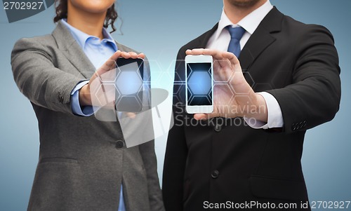 Image of businessman and businesswoman with smartphones