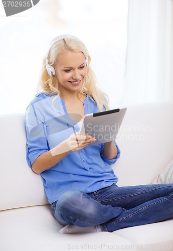 Image of woman with tablet pc and headphones at home