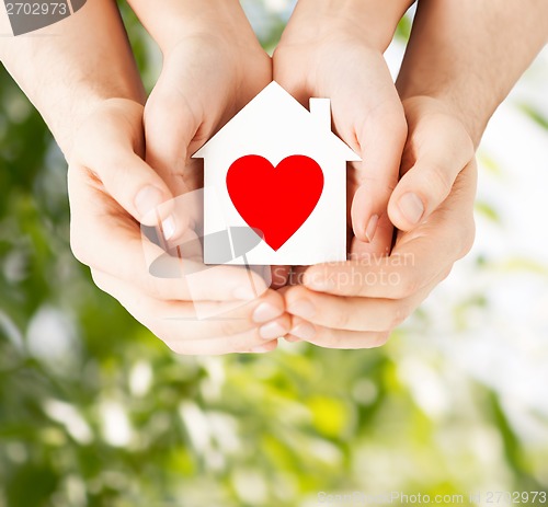 Image of couple hands holding white paper house