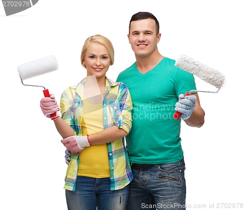 Image of smiling couple in gloves with paint rollers