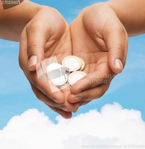 Image of womans cupped hands showing euro coins