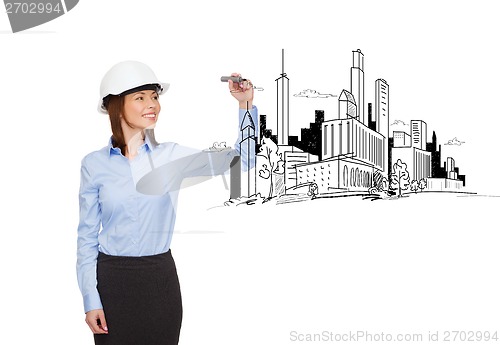 Image of businesswoman in helmet writing on virtual screen