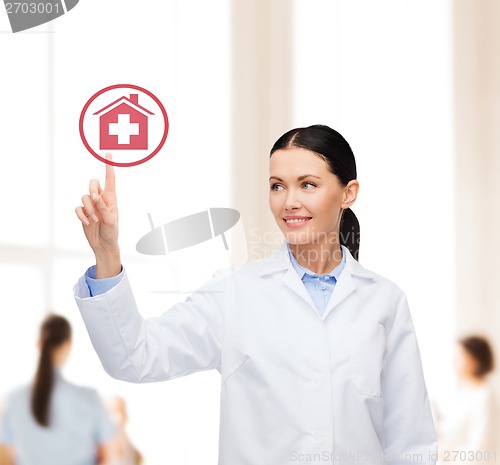 Image of smiling female doctor pointing to hospital sign