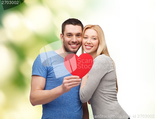 Image of smiling couple holding big red heart