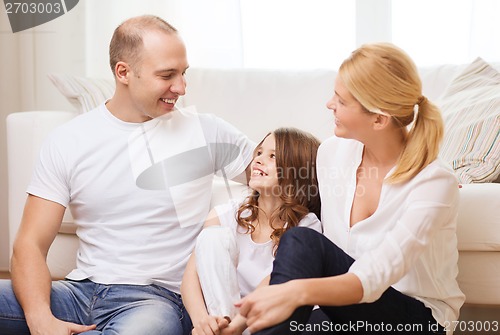 Image of parents and little girl sitting on floor at home