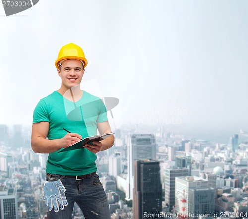 Image of smiling man in helmet with clipboard