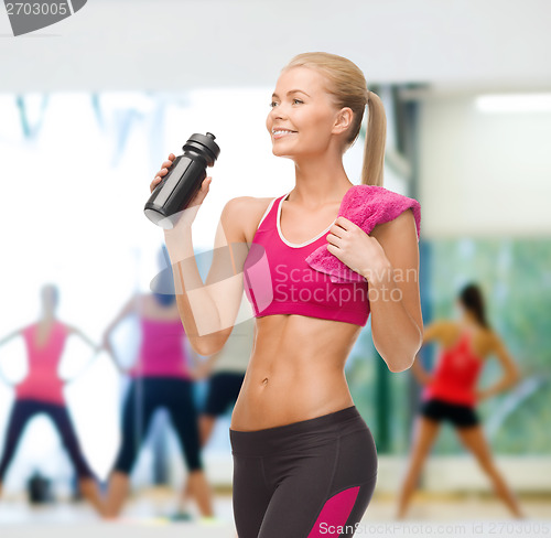 Image of sporty woman drinking water from sportsman bottle