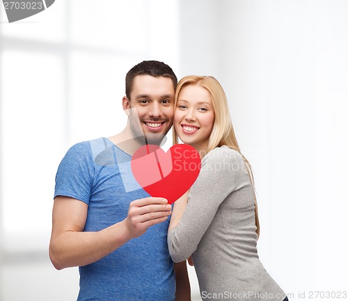 Image of smiling couple holding big red heart