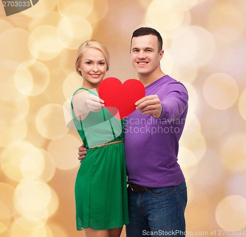 Image of smiling couple holding big red heart