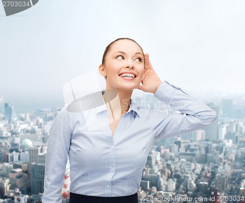 Image of smiling businesswoman listening gossig