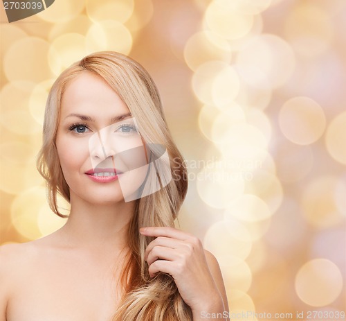 Image of beautiful woman playing with long hair